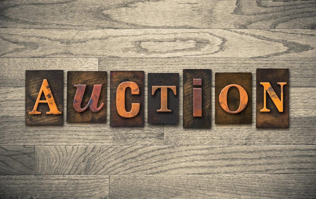 photo of the word auction on wood grain background
