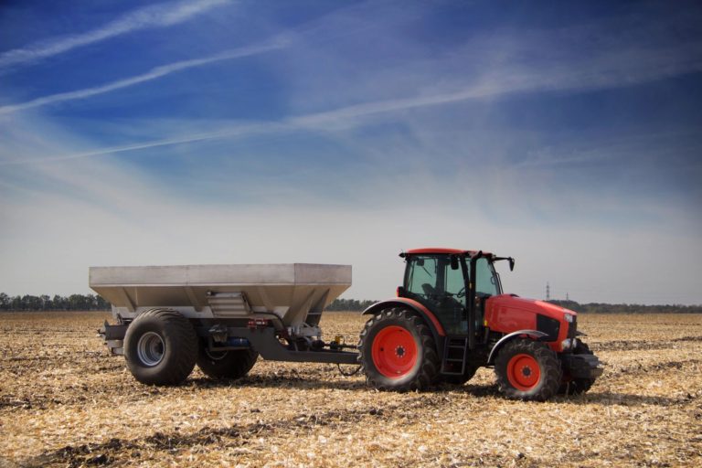 photo of new holland tractor and fertilizer cart